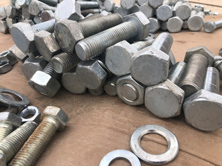 Steel nuts, bolts and washers piled in the box. Fastening construction equipment
