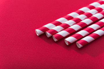 Bright colored cocktail straw on a color red background