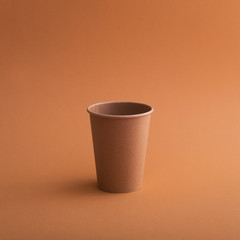 Empty paper coffee cup on a brown background