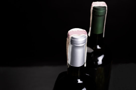 Two bottles of wine with excise tax band. A studio photo on a black background, top view.