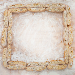 Cookies with almonds on a cutting Board with flour laid out in a square. Top view. Flat lay. Copy space. Background.