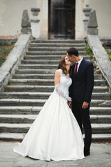 Beautiful bride and groom embracing and kissing on their wedding day