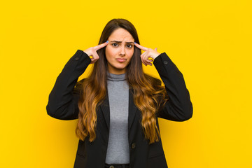 young pretty woman with a serious and concentrated look, brainstorming and thinking about a...