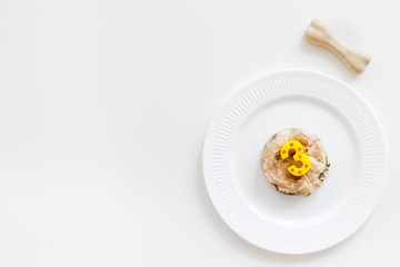 Birthday party for puppy concept. Dog feed, candle in shape of number three, bones on white background top-down copy space