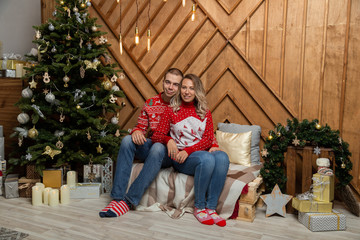 Fototapeta na wymiar Beautiful happy couple in love in the Christmas decor for Christmas night. Happy Merry Christmas 2020.