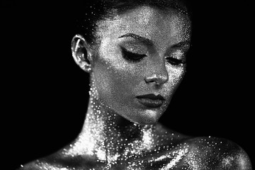 Fashion model woman in bright sparkles and lights posing in studio. Portrait of beautiful sexy...