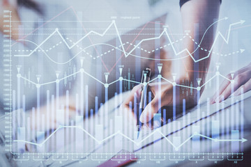 A woman hands writing information about stock market in notepad. Forex chart holograms in front. Concept of research. Double exposure