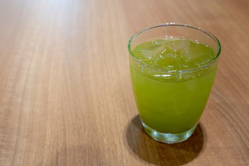 Ice green tea in glass on wooden tabel.