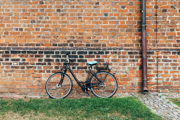 Fototapeta na wymiar Bicycle parked against old brick wall of church in Wismar, Germany