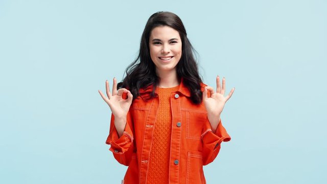 happy girl showing ok signs isolated on blue