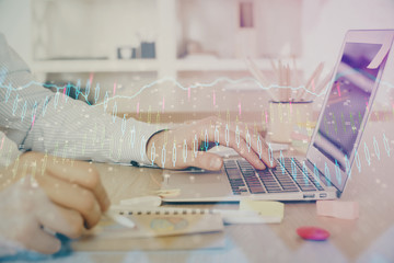 Multi exposure of stock market graph with man working on laptop on background. Concept of financial analysis.