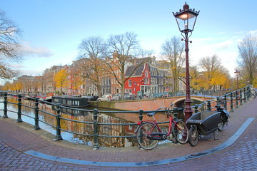 The junction between Prinsengracht Canal and Reguliersgracht Canal, with Autumn colors and colorful facades, Amsterdam, Netherlands