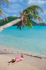 Obraz na płótnie Canvas Young woman on a tropical beach with hat
