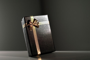 An elegant black box with golden bow