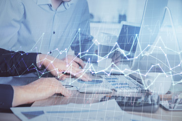 Multi exposure of chart with man typing on computer in office on background. Concept of hard work.