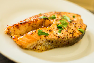 cook salmon in white plate with honey and mustard
