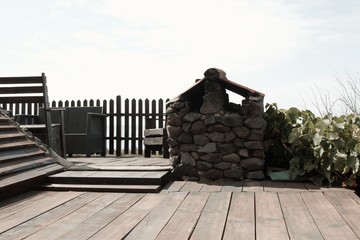 Wooden floor in the garden with an old stone oven and a wooden fence (Madeira, Portugal, Europe)