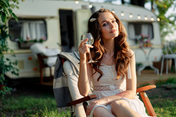 Beautiful young woman relax in chair during picnic beside her camper van