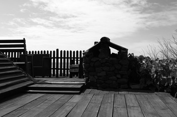 Wooden floor in the garden with an old stone oven and a wooden fence (Madeira, Portugal, Europe)