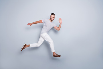 Full length body size view of his he nice attractive cheerful cheery glad strong fit bearded guy running fast waving hi hello training isolated over light grey pastel color background