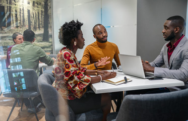 Black african business team meeting in discussion sitting in office canteen. Financial planning