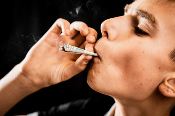 A teen Smoking a cigarette or drugs is a rolled dollar, the concept of teen addiction and spending money on cigarettes