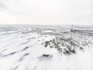 Aerial winter landscape of the Baltic Sea and frozen Curonian Lagoon near the town of Nida