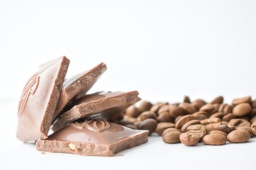 Coffee beans and chocolate bars on white background.