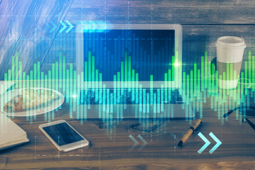 Double exposure of graph and financial info and work space with computer background. Concept of international online trading.