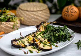 grilled aubergine slices garnished with melted cheese and tarragon