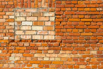 Red brick wall with bricked up window