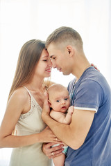 young couple with newborn baby. vertical white background