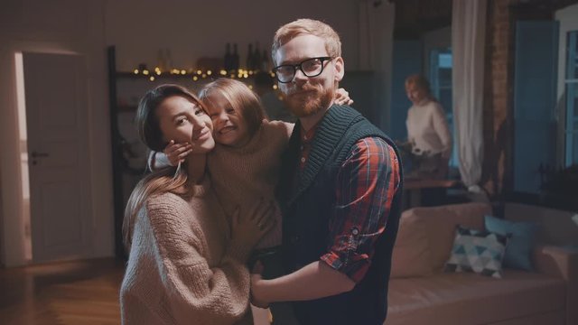 Father, mother and daughter hugging each other on Christmas eve