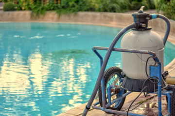 Fototapeta na wymiar Swimming pool cleaning machine with water pool background.
