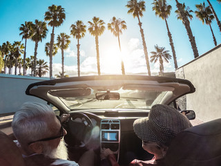 Senior trendy couple inside a convertible car - Main focus on woman hat