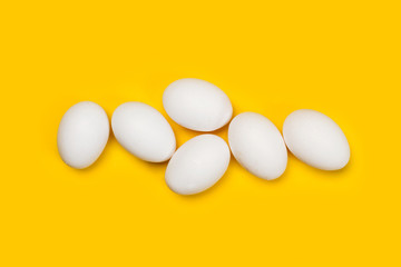 Huevos blancos sobre fondo amarillo aislado. Vista superior. Copy space