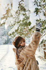 Young girl enjoying snow outdoors in winter.