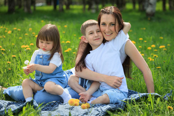 Fototapeta premium Happy smiling mother and her children playing in the park
