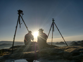 Creative artists stay at own cameras on tripods.  Hikers and enthusiasts