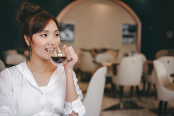 Young cheerful woman drinking hot coffe at coffee shop and restaurant in morning time with breakfast meal. Feeling happiness and relax with smiling face before going to wok  