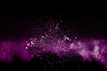 Purple color powder explosion cloud  on black background.Closeup of Purple dust particles splash on  background.