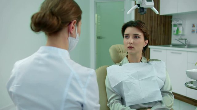 Dentist in mask friendly talks to a girl 