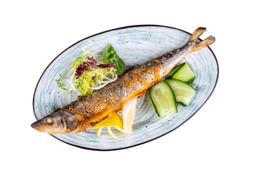 Fish fried on coal with lettuce leaves and cucumbers