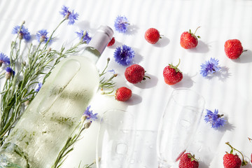 a bottle of white wine and strawberries