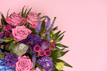 Beautiful bouquet of pink, purple and blue flowers on pastel pink background, copy space. Greeting card for Womens Day, Mothers Day, Valentines Day, wedding, birthday. Top view, flat lay