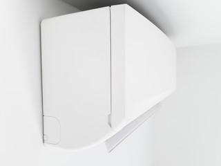 Modern air condition unit on a white wall inside the living room.