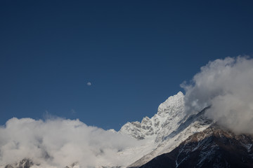 clouds in mountains with visible moon