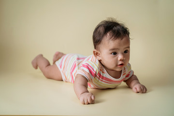 Naklejka premium cute baby laying on her belly looking at camera