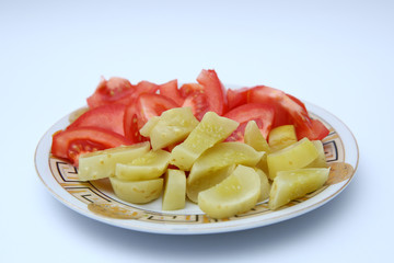 Plate of vegetable salad with fresh tomatoes and cucumbers on wooden background, top view