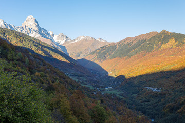 Panoramic  views of the mountains and Ushguli peak in the snow, visible in the distance, in the mountainous part of Georgia - Svaneti at sunset